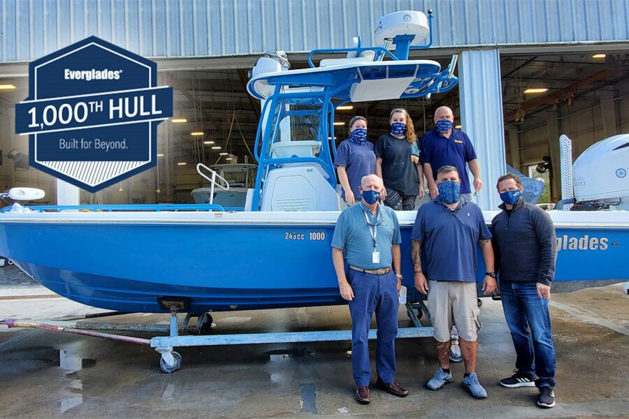 Group of people standing by the 1,000th HULL that Everglades Boats has built