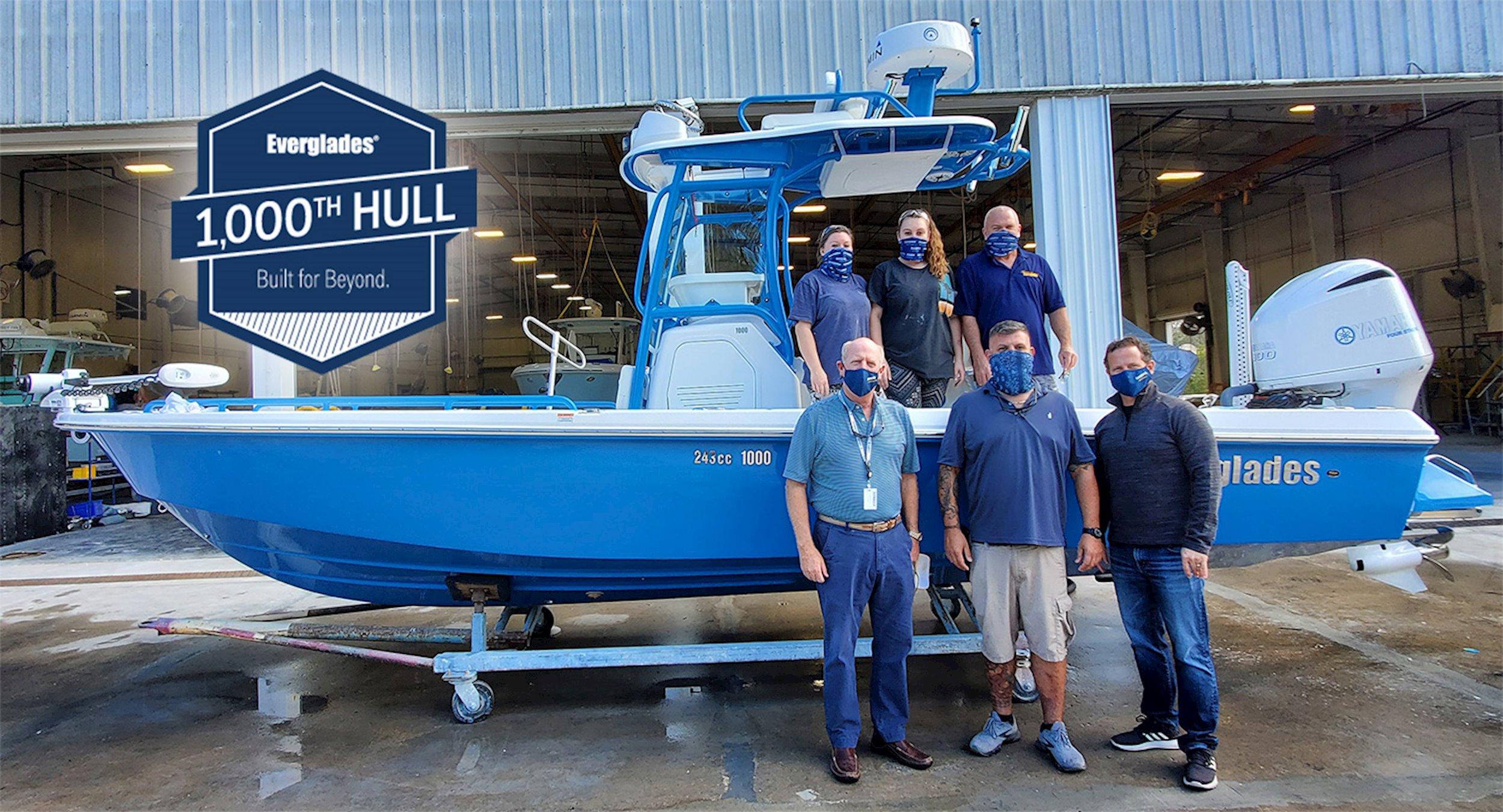 Group of people standing by the 1,000th HULL that Everglades Boats has built