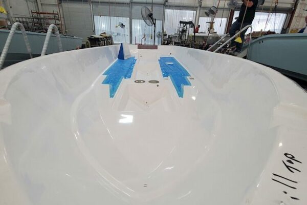 White Everglades boat hull interior with blue tape markers in a workshop setting