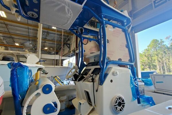 A partially assembled Everglades boat interior with exposed wiring and components, under a factory setting