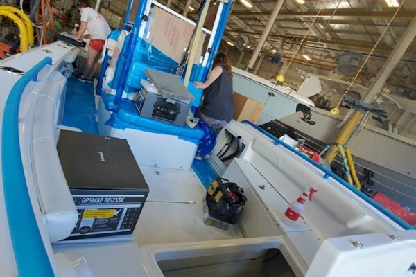 Interior of an Everglades boat with workers and boat parts inside a factory