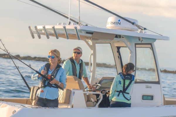 People on an Everglades boat with fishing gear, near the shore during daytime