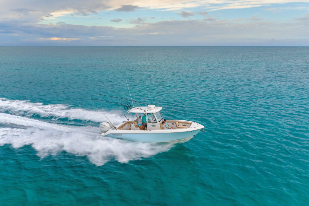 822 A white Everglades boat with passengers creating a wake on a tranquil blue ocean