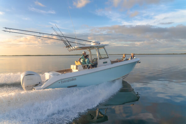 Everglades fishing boat with passengers cruising on calm waters at sunrise