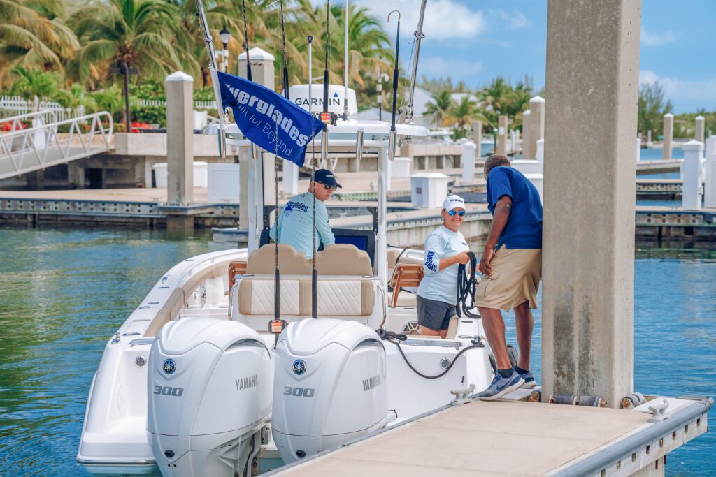 832 A boat docked at a pier with two people standing beside it, holding a rope