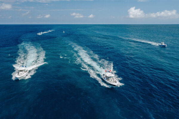 DJI_0567_7980 Aerial view of multiple boats speeding across the open ocean, leaving white water trails behind them