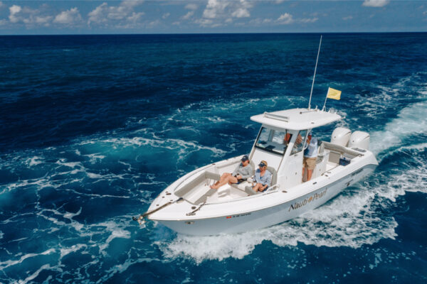 DJI_0576_4323 An Everglades boat cruising through deep blue water with several people on board under a partly cloudy sky