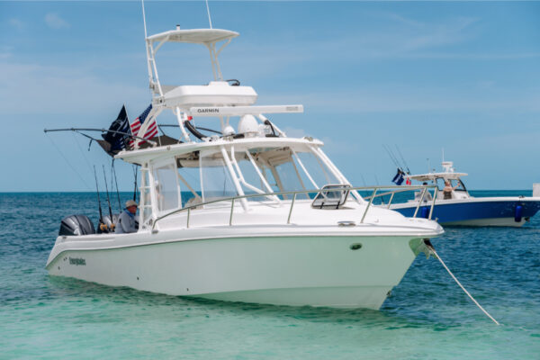JJS00251_835 An Everglades boat anchored in shallow turquoise water with fishing rods and flags visible and another boat in the background