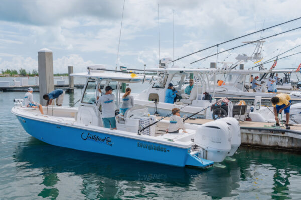 JJS06895_9924 People preparing an Everglades boat at a marina dock under cloudy skies