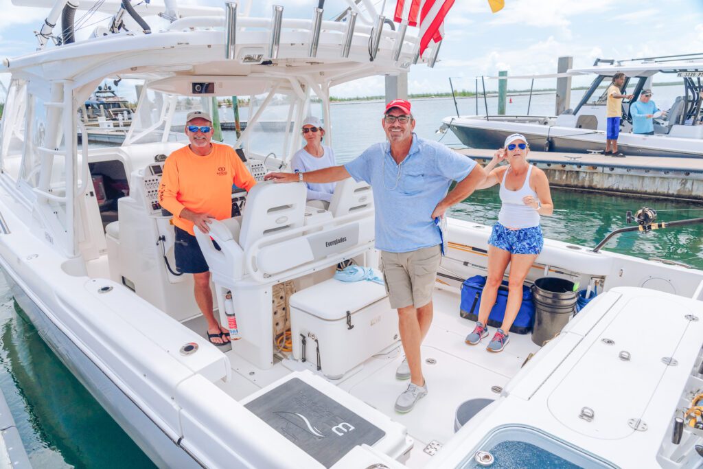 JJS06908 A group of people posing together on the back of a docked Everglades boat