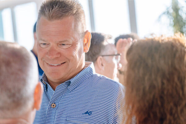 JJS07376_9428 Group of people in a sunlit room, one in a blue checked shirt