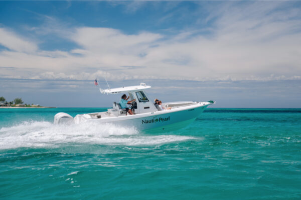 JJS09774_8151 An Everglades boat speeding across turquoise water with passengers on board and a partly cloudy sky in the background