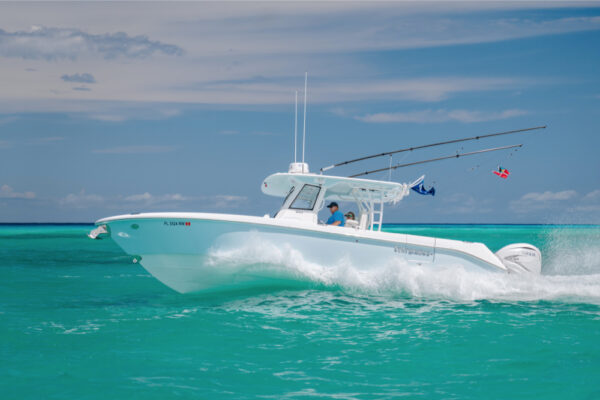 JJS09802_7706 An Everglades boat speeding across turquoise water with fishing rods and flags visible under a partly cloudy sky